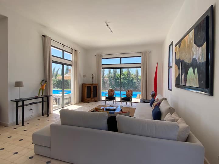 Obývacia izba pri bazéne s veľkou modernou a pohodlnou pohovkou