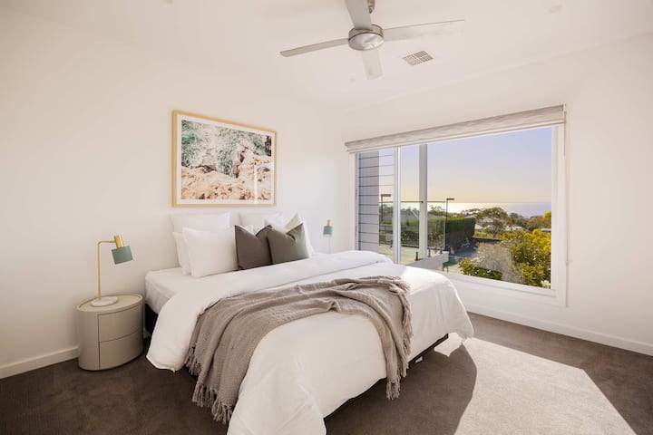 Serene Bedroom Retreat I Discover utulivu katika chumba hiki cha kulala kilichobuniwa vizuri kilicho na kitanda cha ukubwa wa kifalme chenye nafasi kubwa, kilicho chini ya dirisha kubwa la kioo ambalo hutoa mandhari ya kupendeza na kujaza chumba kwa mwanga wa asili.