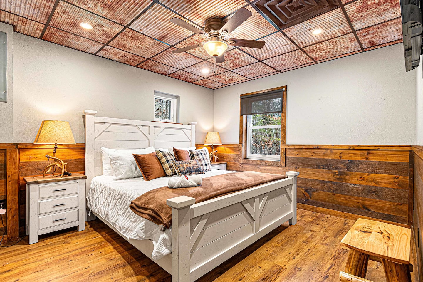Guest Bedroom 2 — farmhouse king bed, basement level, tin ceiling
