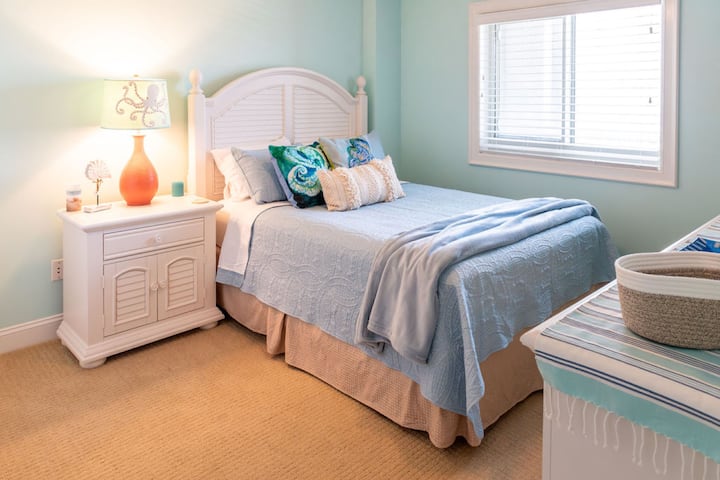 סרניטי גרה כאן - חדר שינה 3 כולל מיטת קווין סייז וגוונים של חול ושמיים שלווים, ויוצרים מקום מפלט מושלם אחרי יום בשמש.