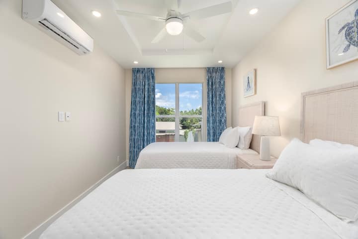 Cómodo segundo dormitorio con dos camas convertibles y vistas al jardín
