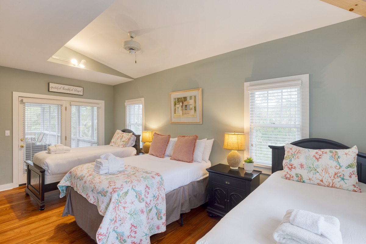 La chambre 4 dispose d'un lit double et de deux lits jumeaux. Offre également un accès à la salle de bain 4.