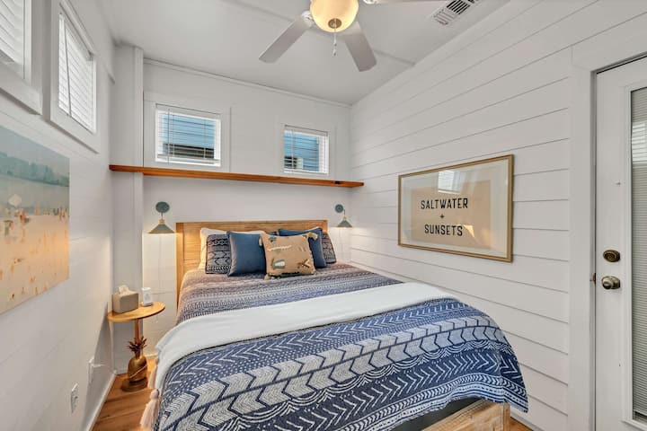 Bedroom includes Queen bed (new mattress), new flooring, artwork, blinds in all windows, lighting, and wireless charger. TV, luggage rack, and shelves for clothing