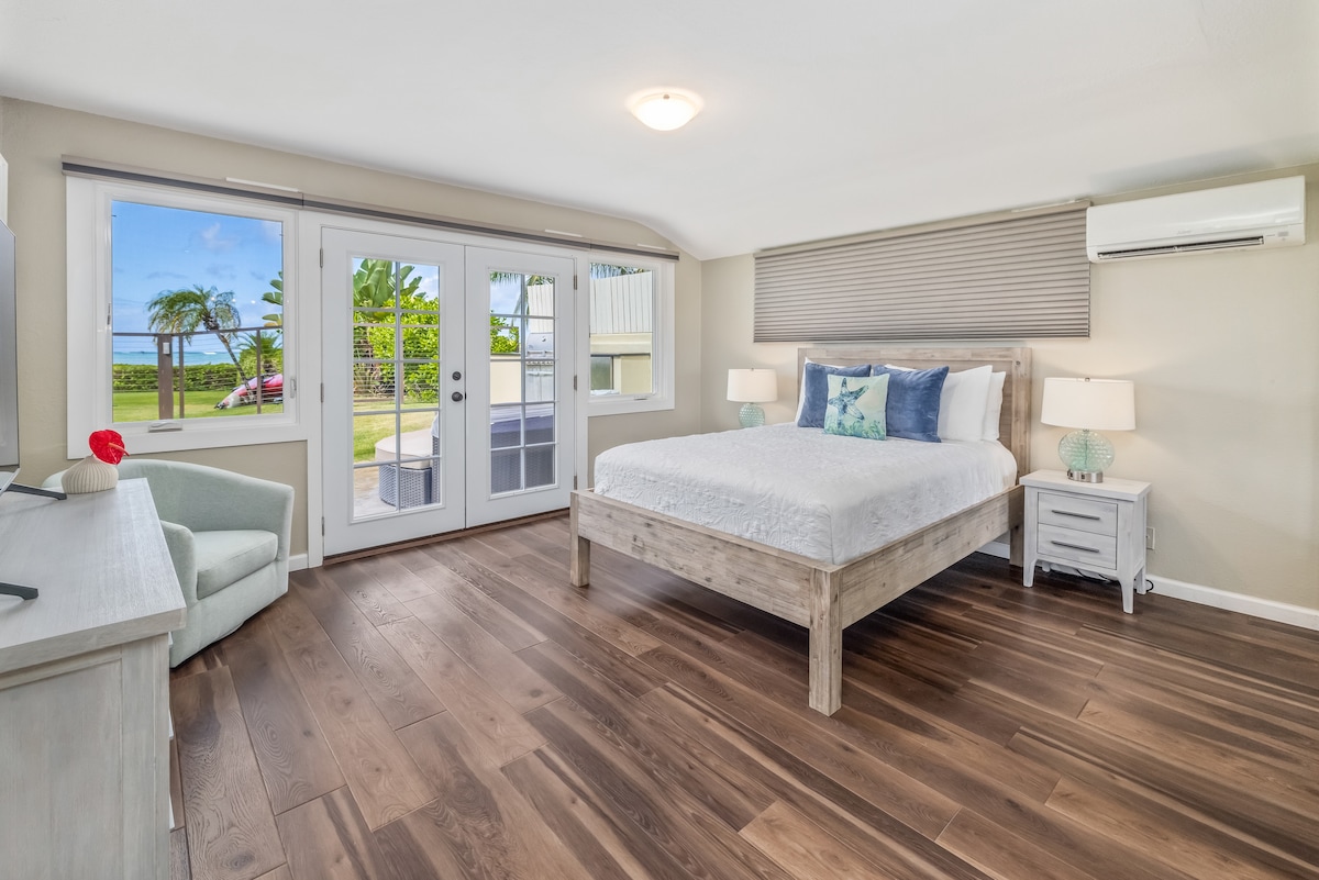The secondary suite offers a queen-sized bed and doors leading to a private patio.