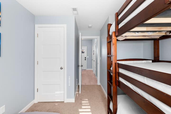 Fun bunk room featuring a triple bunk and a fourth convertible chair bed, comfortably sleeping up to four guests. Perfect for kids or groups, this cozy space is designed for relaxation and playful memories during your Pacific City getaway.