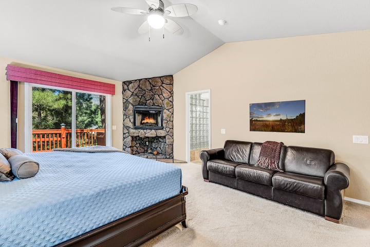 Suite principal 1- Nivel principal: cama tamaño king, sofá cama, chimenea de piedra decorativa, TV de pantalla plana, acceso privado a la cubierta superior y baño privado.