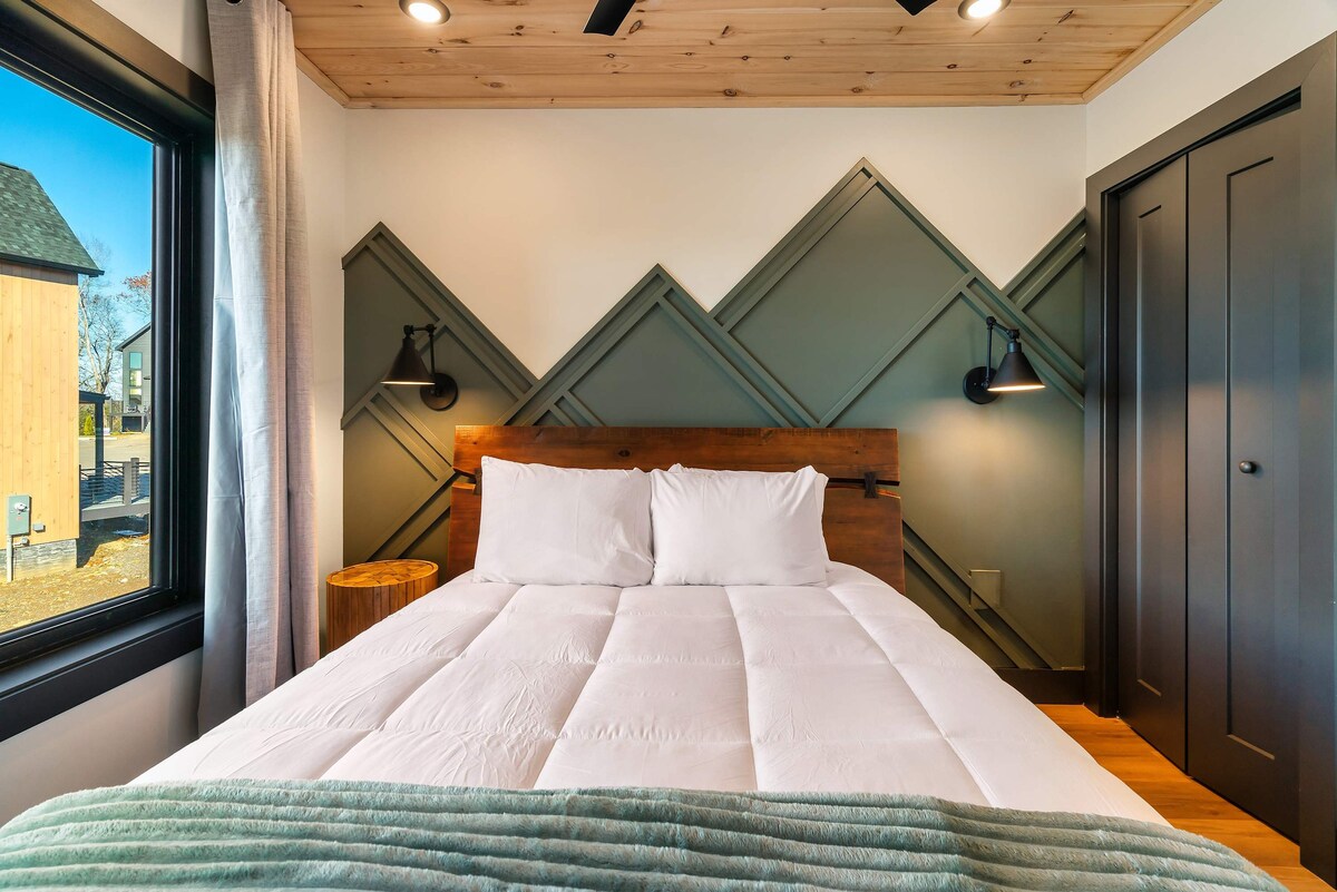 Dhomë gjumi "queen" me mural malor dhe elemente rustike.