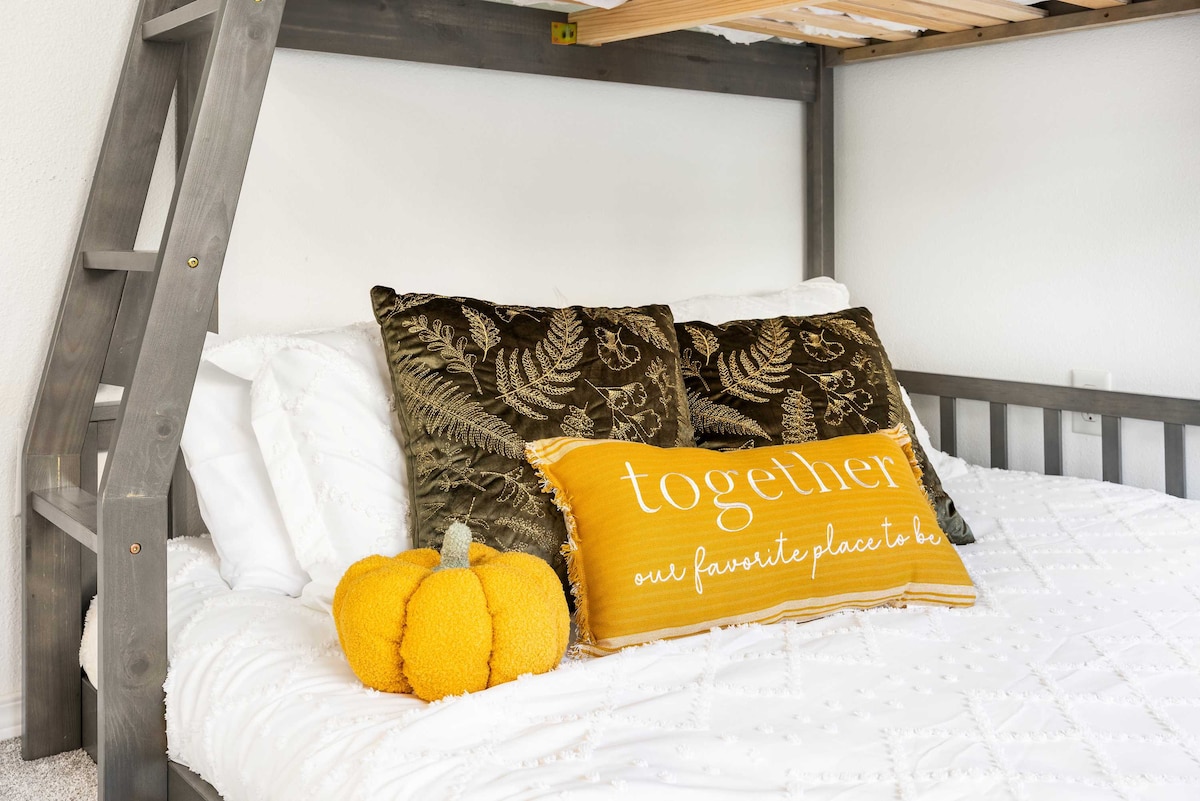 מיטת הקומתיים המזמינה הזו מעוצבת עם כריות נוחות וכרית נוי מקסימה שכתוב עליה "יחד, המקום האהוב עלינו ." עיצוב הדלעת התוסס מוסיף מגע עונתי, מה שגורם לו להרגיש חמים ומזמין.