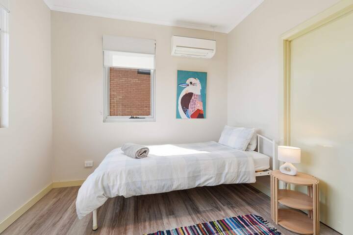 La deuxième chambre est équipée d'un lit simple confortable de très grande taille, de la climatisation/la pompe à chaleur, d'un écran solaire et de stores occultants, ainsi que de deux ports de recharge USB à la tête du lit, d'une armoire intégrée et d'une commode.