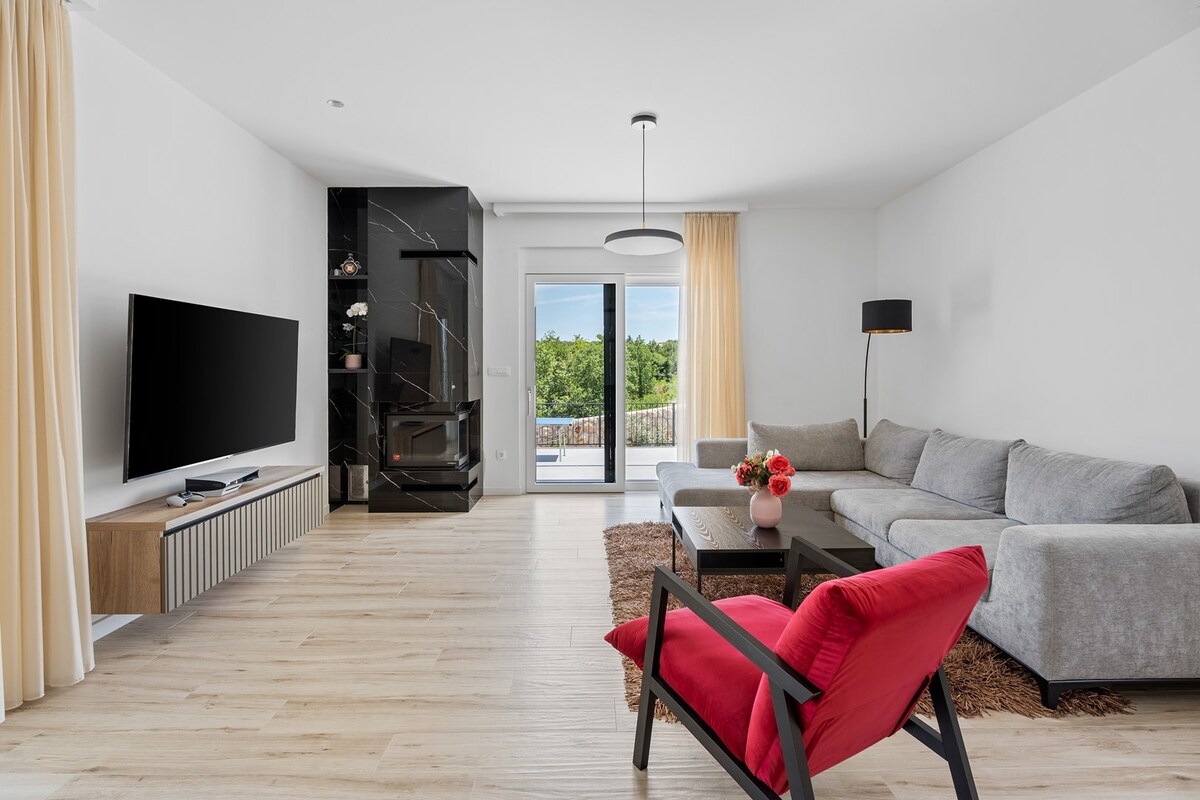 ห้องนั่งเล่นที่ตกแต่งอย่างหรูหราประกอบด้วยโซฟาที่สะดวกสบายทีวีและเครื่องปรับอากาศ
