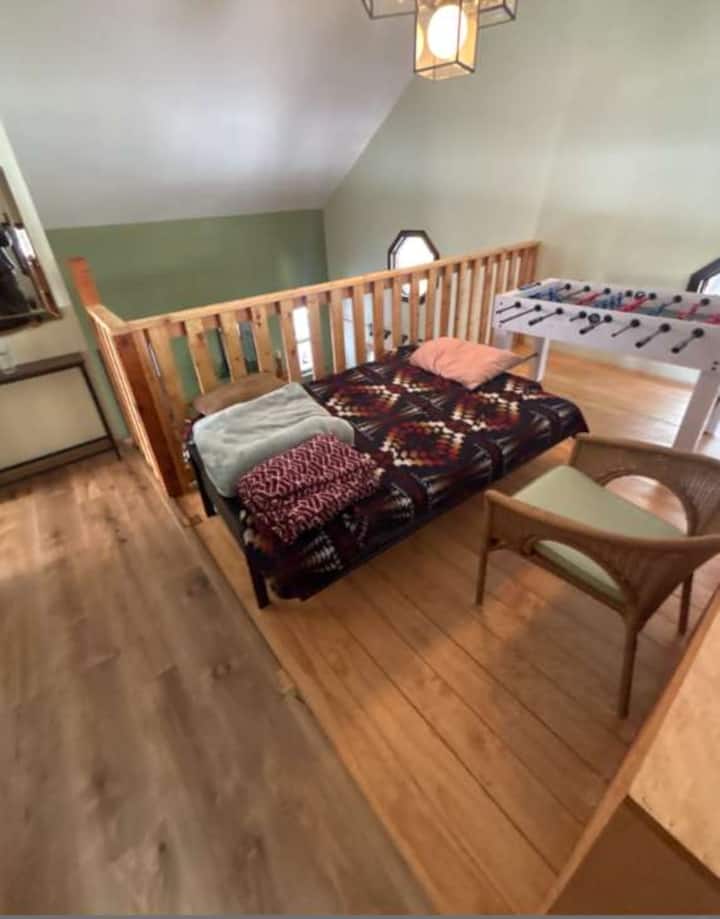 Área del loft: futón y mesa de juegos