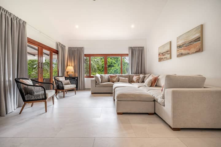 Sala de estar de concepto abierto con muebles elegantes y grandes puertas de vidrio