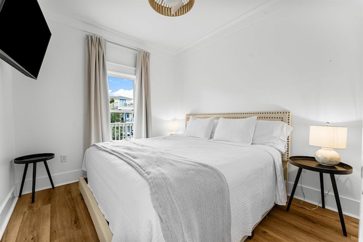 Este dormitorio en el segundo piso cuenta con una cama tamaño king, un armario con cómoda y un televisor inteligente, que ofrece un espacio cómodo y bien equipado para los huéspedes.