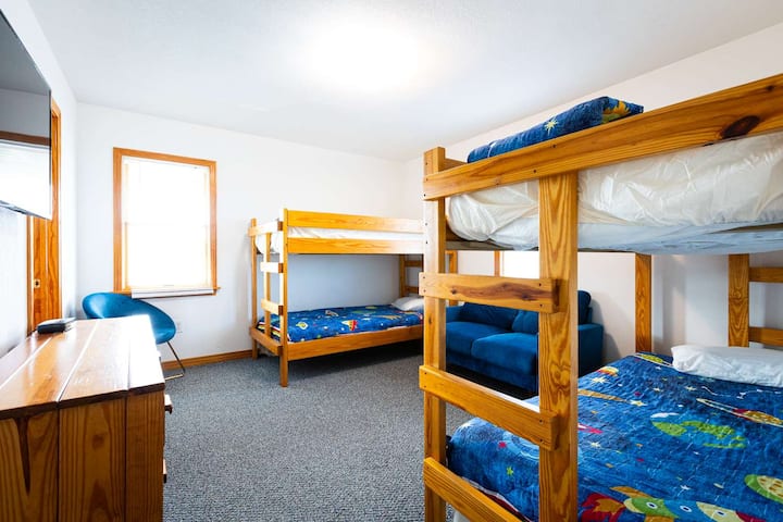 Quarto principal de nível médio com dois beliches, TV e sofá