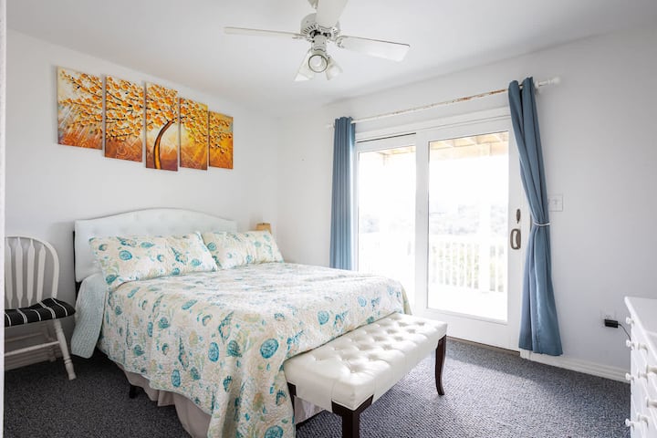 Quarto principal Queen de nível médio com banheiro privativo completo, acesso ao deck e TV