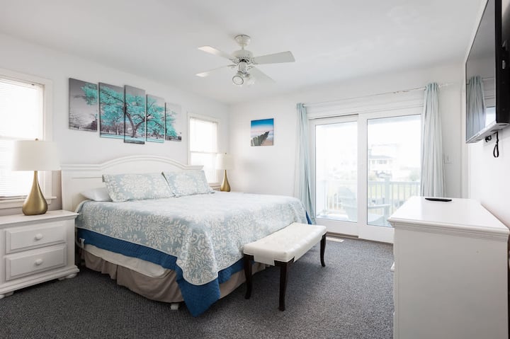 Quarto principal king de nível médio com banheiro completo, acesso ao deck e TV
