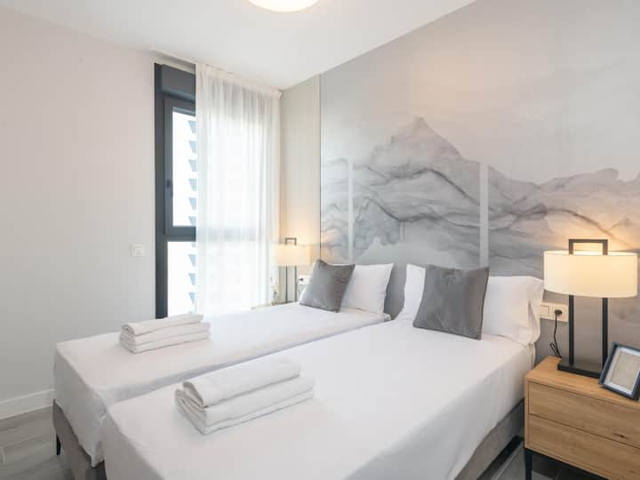 Dormitorio elegante y luminoso, con un diseño contemporáneo que combina tonos neutros y contrastes sofisticados.