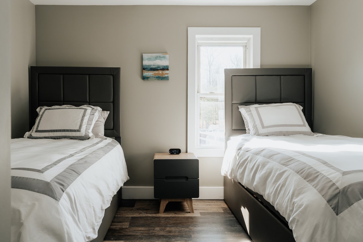 Una habitación luminosa y luminosa con dos camas individuales y una cama nido para tener mucho espacio adicional para dormir. 