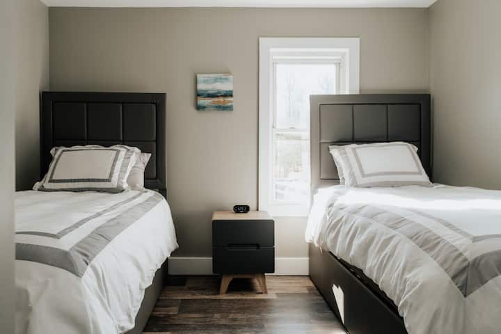 Una habitación luminosa y luminosa con dos camas individuales y una cama nido para tener mucho espacio adicional para dormir.