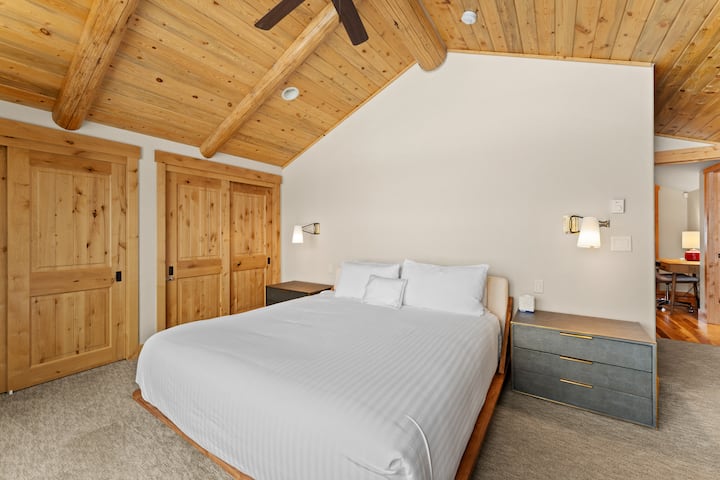 Primárna spálňa s manželskou posteľou King, pracovným priestorom, vlastnou kúpeľňou a veľkými oknami s výhľadom na hory. 