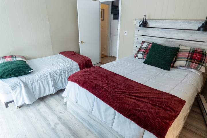 Cama tamaño queen y dos camas individuales en el dormitorio tres.