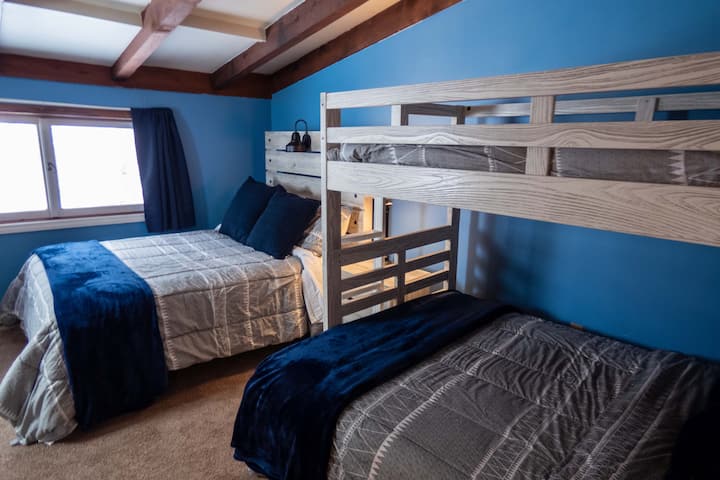 Dos camas completas y una individual en el segundo dormitorio en el nivel superior.