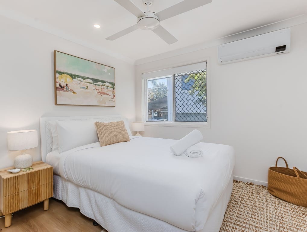 Uprataná spálňa so stropným ventilátorom.