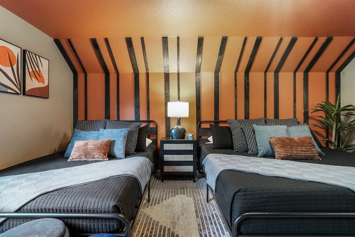 Prostrana spavaća soba s jednim bračnim krevetom i jednim bračnim krevetom, uređena s modernim detaljima i skrivenom tajnom špiljom koju mali pustolovi mogu istraživati i igrati se (to je iznenađenje!)