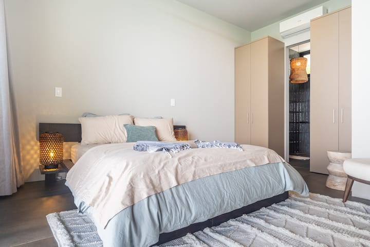 Chumba cha kulala chenye nafasi kubwa, cha kisasa chenye ubunifu wa kifahari, chenye kitanda cha kifahari kwa ajili ya mapumziko ya hali ya juu na mazingira ya amani.