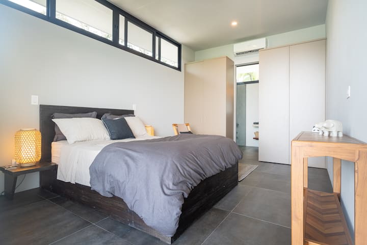 Chumba cha kulala chenye nafasi kubwa, cha kisasa chenye uzuri uliosafishwa, kinachotoa mazingira ya amani na utulivu.