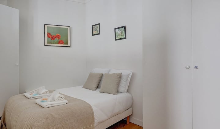 Spavaća soba s modernim okvirima na zidu