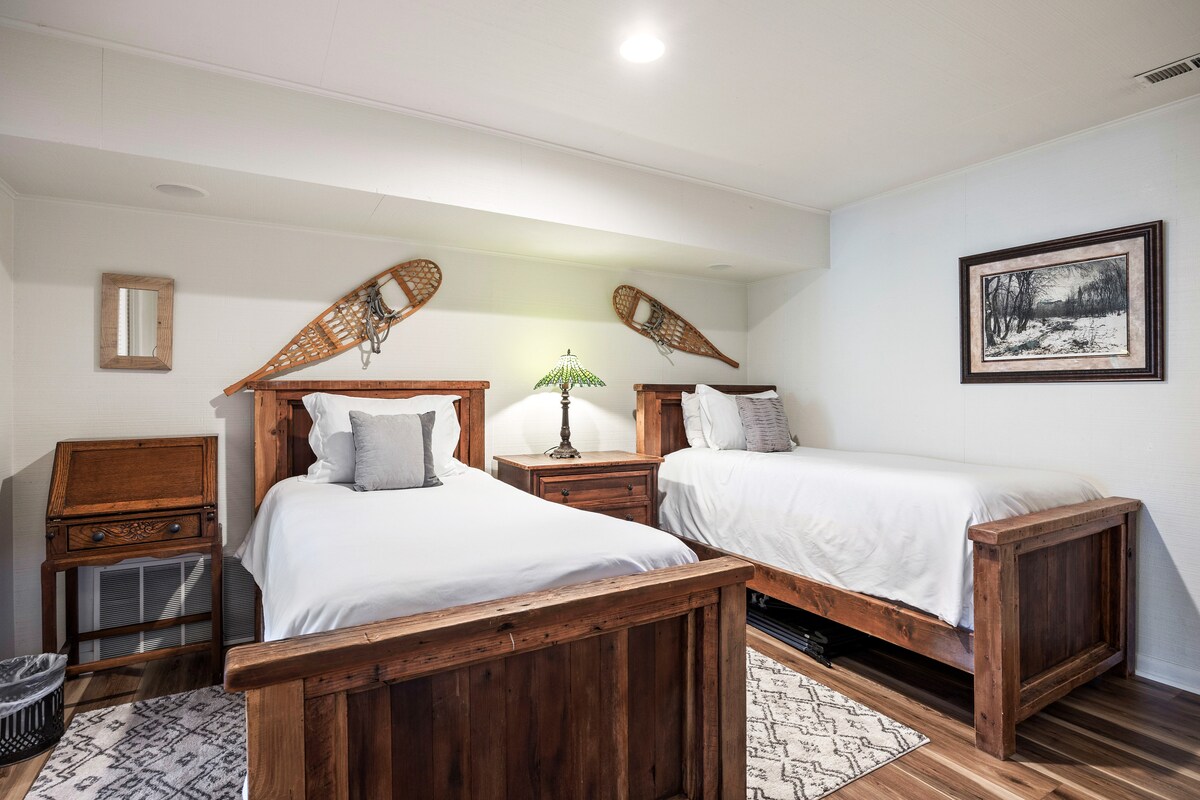 - სტუმრების საძინებელი ორადგილიანი საწოლებით, რომლებიც სოფლის ხის ჩარჩოებითა და დეკორით გამოირჩევა  
- თოვლის ფეხსაცმლის კედლის აქცენტები ხაზს უსვამს მთის შთაგონებულ ხის სახლის დიზაინს  
- რბილი თეთრეული და მყუდრო განათება ამ მიმზიდველ დასვენებას ქმნის