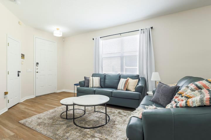 Bright and comfortable, this living room features rich leather couches, a large smart TV, and stylish décor perfect for relaxing after a day of exploring.