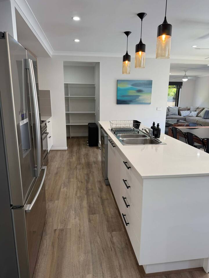 Модерна и целосно опремена кујна со машина за миење садови, голем фрижидер, рерна, шпорет, чајник, тостер и шпајз