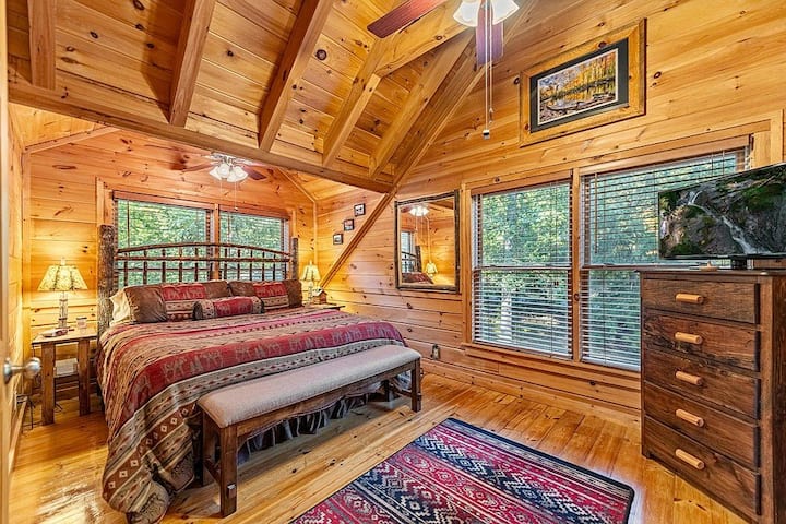 ห้องนอนหลักขนาดคิงไซส์มีทีวีในห้องพัดลมติดเพดานตู้เสื้อผ้าม้านั่งและตู้เสื้อผ้าพร้อมไม้แขวนเสื้อและชั้นวางกระเป๋าเดินทาง