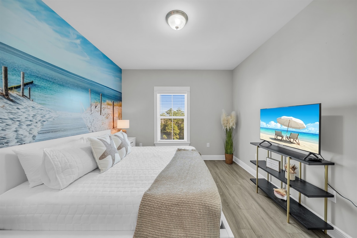 La chambre 2 offre un lit KING en bambou avec 4 oreillers king pour une nuit de sommeil de rêve.  Elle comprend également une salle de bain attenante pour votre intimité.  La fresque vous transporte à la plage pendant que vous vous laissez bercer par les sons de l'océan grâce à la machine à bruit blanc.