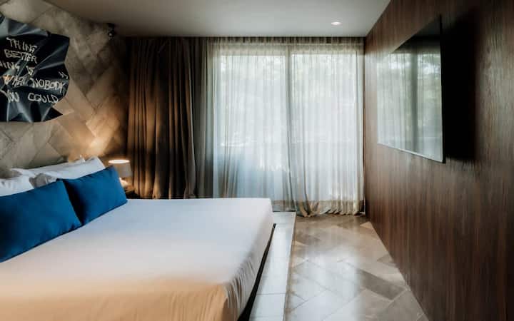 Dormitorio tamaño queen con baño completo y televisor inteligente
