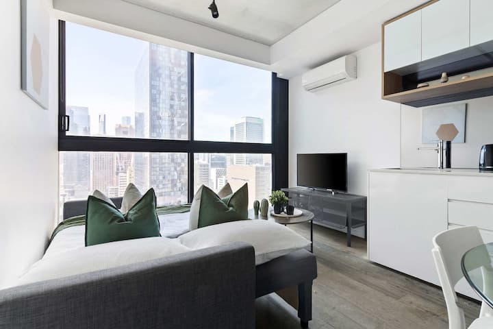 Uma área de estar moderna com um sofá-cama de 3 lugares que se dobra para um casal e para a cidade.
