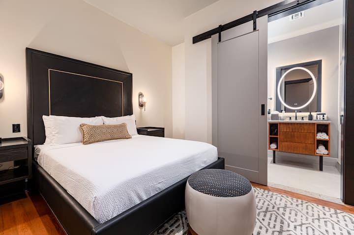 חדר שינה 1 - מיטת קווין סייז הכוללת ארון בגדים מובנה, טלוויזיה בעלת מסך שטוח וחדר רחצה צמוד.