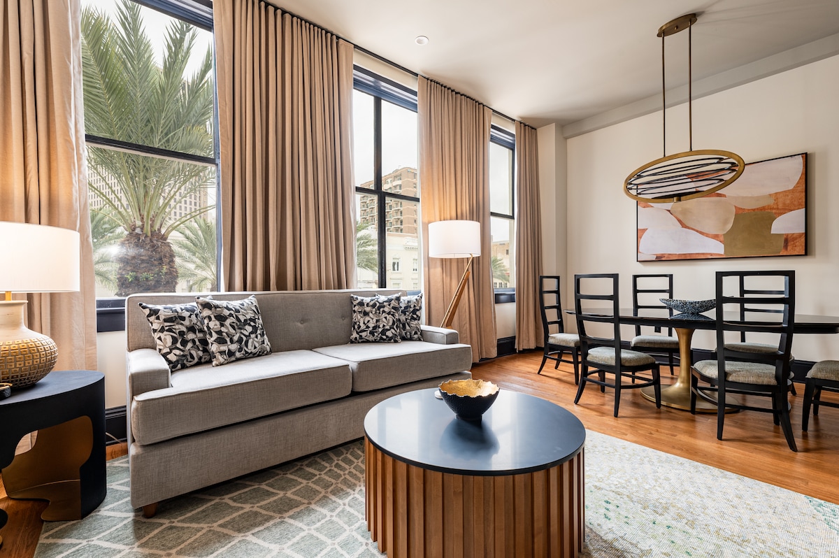 Елегантно жилищно пространство с изглед към улица „Канал “, оформено от високи прозорци, които заливат стаята със светлина и предлагат оживен изглед към градския пейзаж.