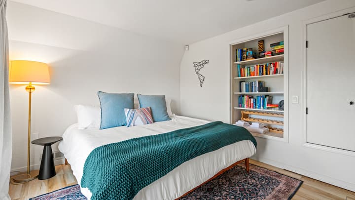 Dormitorio del nivel inferior con acceso a la terraza proporcionado por puertas correderas de vidrio. Este espacio ofrece una zona de lectura tranquila con hermosas vistas. 