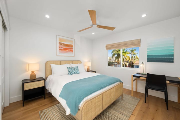 At the end of the 2nd floor hallway is the third bedroom which features a queen bed, complete with luxury white bedding and a new comfortable mattress. A workstation is located in this room with a spacious desk with drawers, a desk lamp and chair.