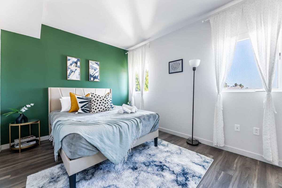 Bright and restful ambiance with floor-length drapes and layered textures for a boutique-hotel feel.