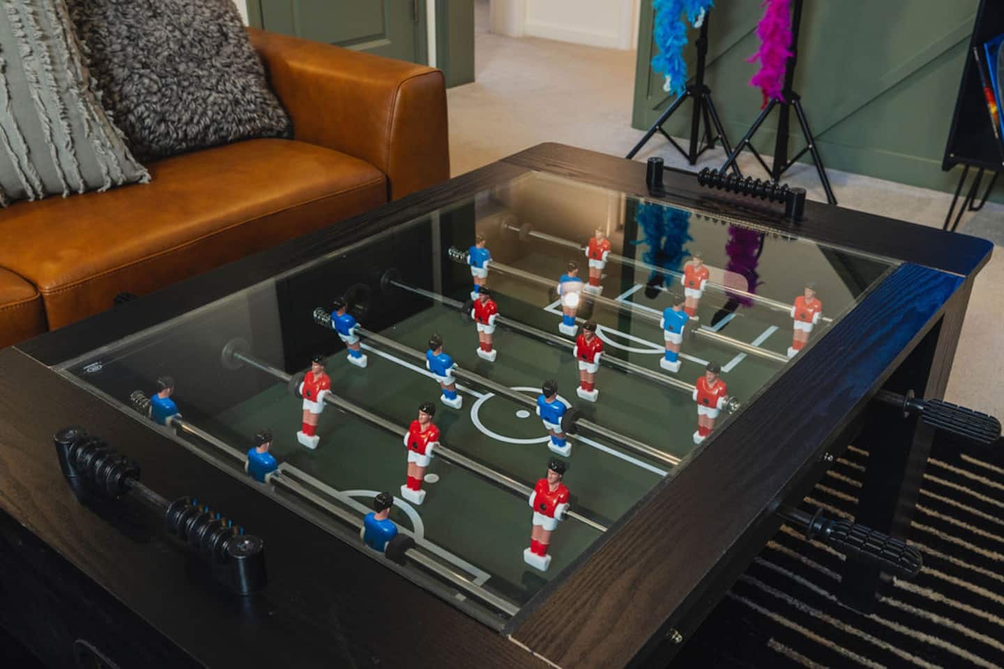 Set your drink down carefully on this one, the coffee table doubles as a working foosball game. Someone's about to start a match.