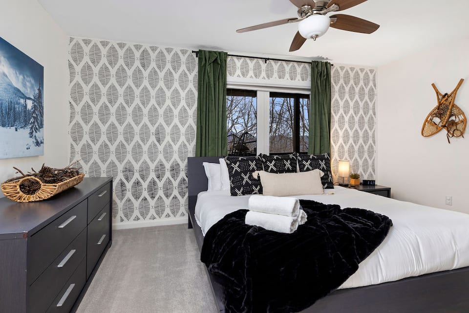 Ski Lodge King bedroom with mountain artwork and snowshoes on the wall