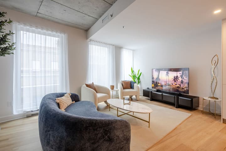 غرفة معيشة واسعة مع مقاعد مريحة وتلفزيون كبير