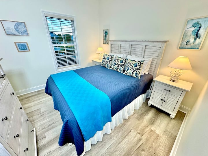 Queen bed with a smart TV and blackout curtains.