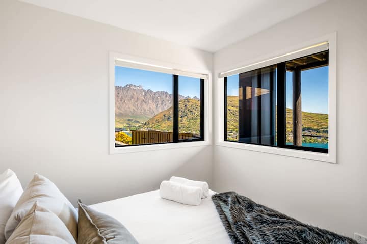 Štvrtá spálňa s výhľadom na hory – táto príjemná štvrtá spálňa ponúka rozsiahle okná, ktoré prezentujú ohromujúce hory Queenstown a poskytujú hosťom pokojné a malebné útočisko.