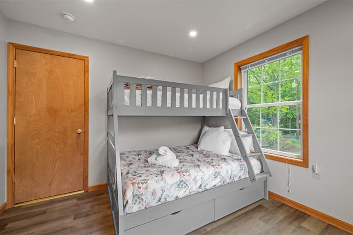 Уютна спалня с двуетажно легло и малко работно място, идеално за деца или дистанционна работа.