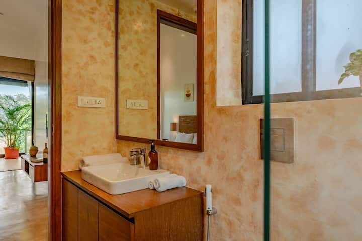 ✨Warm textures, soft lighting, and a view into the lush outdoors make this bathroom feel both cozy and open✨